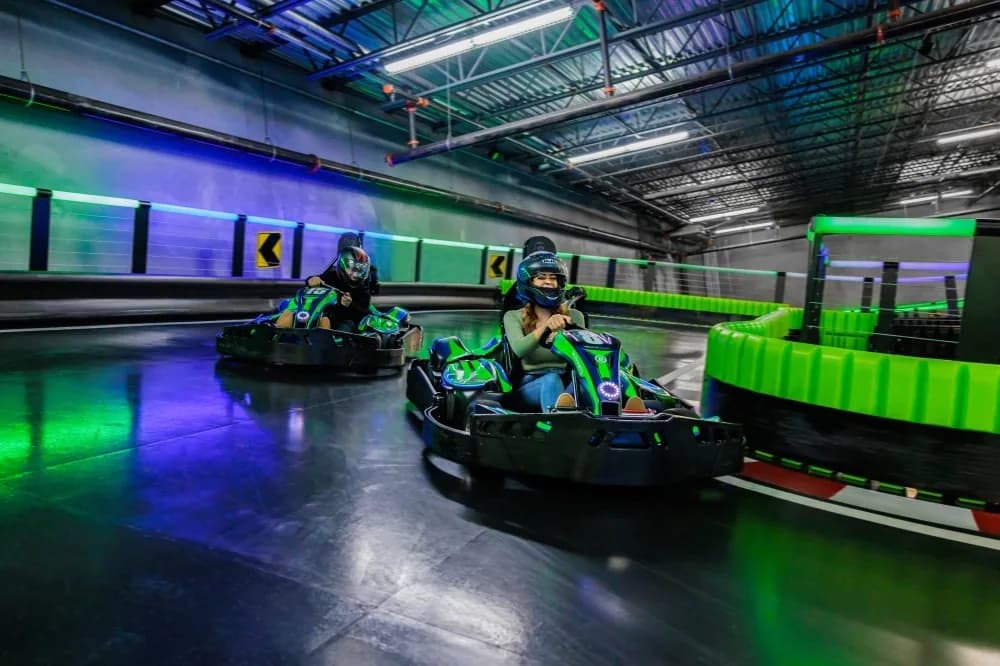 Guests racing go-karts on an indoor track at a family entertainment center